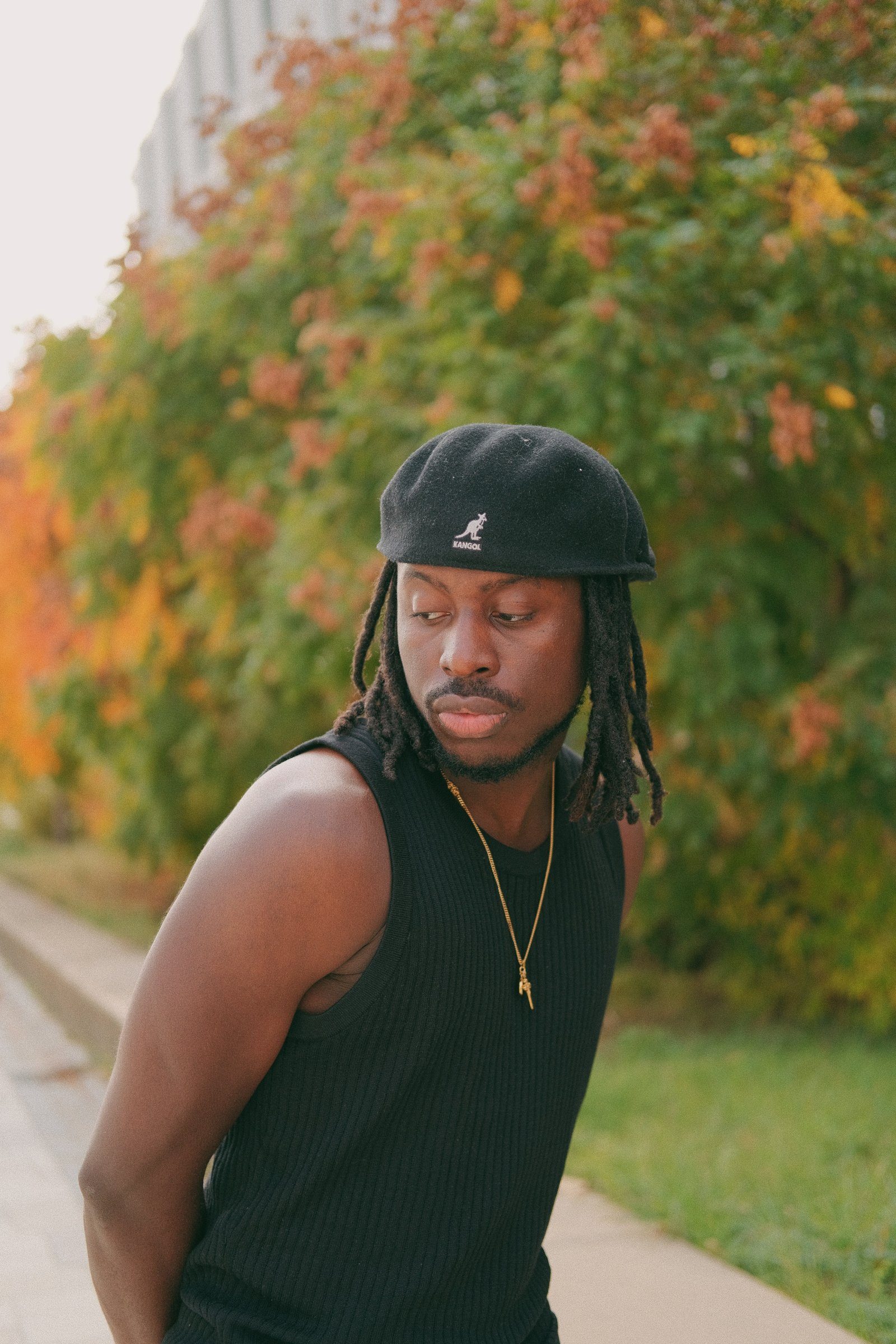 Tmaro in a black Kangol beret and black tank top